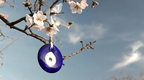 Evil Eye Amulet Hangs on a Blossoming Tree. 4k Stock Footage 61329190