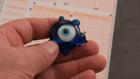 Evil eye bead and optical exam paper, exam and luck Stock Footage 124788747