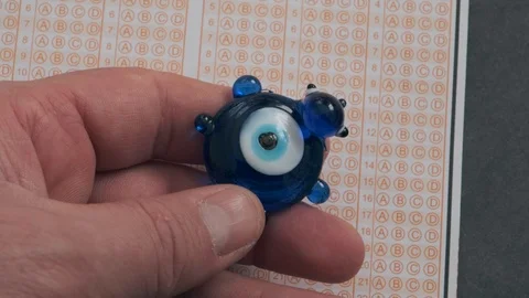 Evil eye bead and optical exam paper, exam and luck Stock Footage 124788762