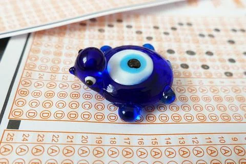 Evil eye bead and optical exam paper, exam and luck, Stock Photos