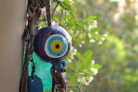 Evil eye bead next to jasmine flower Stock Photos