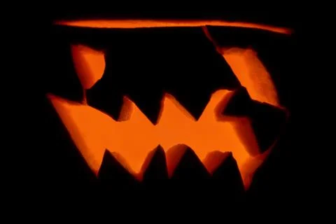 Evil glowing burning pumpkin jack lantern for Halloween on a black background Stock Illustration