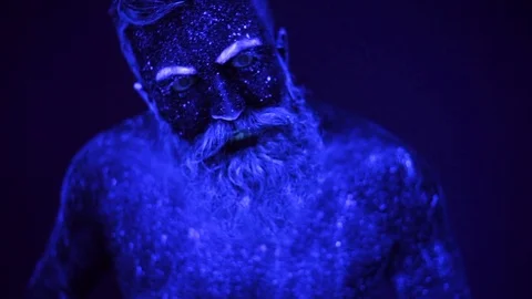 An evil man with a beard in the ultraviolet light is frighteningly screaming Video stock 81207695