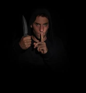 Evil man gesturing silence while holding a knife Stock Photos