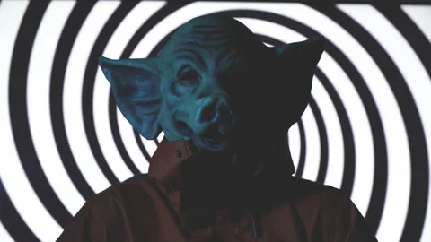 Evil man with killer pig mask sitting on chair with psychedelic spiral Stock Footage 221043456