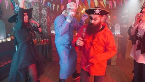 Evil pirate dancing in the middle of a group of friends celebrating halloween Stock Footage 107971547