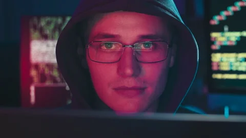 The evil programmer's face is illuminated in red Stock Footage 180468691