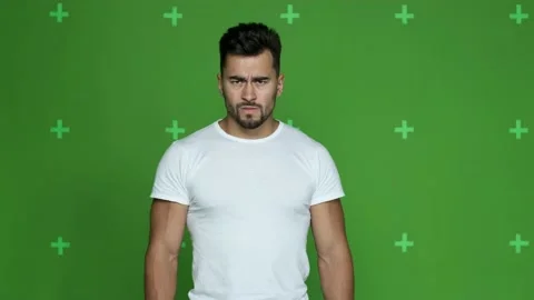 Evil pumped guy in white t-shirt looks into camera Stock Footage 130831482