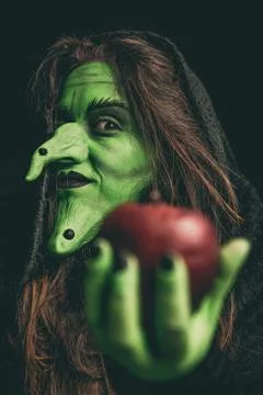 Evil witch holding a red apple 写真素材