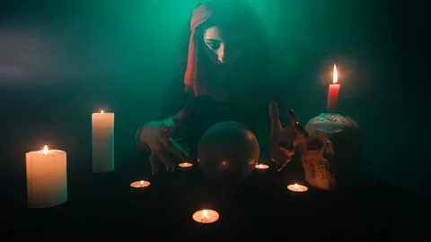 Evil witch sitting in the smoke and luring, reaching her hands out Stock Footage 101373605