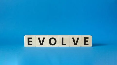Evolve symbol. Concept word Evolve on wooden cubes. Beautiful blue backgrou.. Foto stock