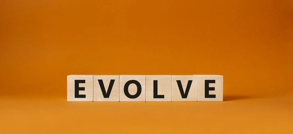 Evolve symbol. Concept word Evolve on wooden cubes. Beautiful orange backgr.. Foto stock