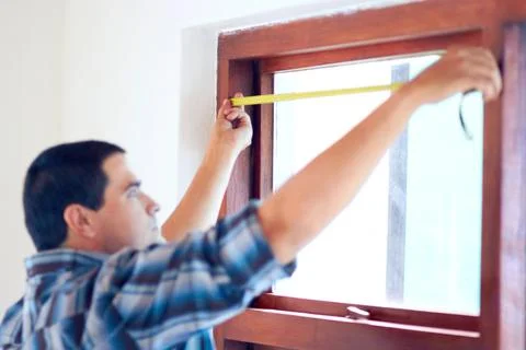 The exact measurement. Shot of a middle aged handy man measuring a window. Stock Photos