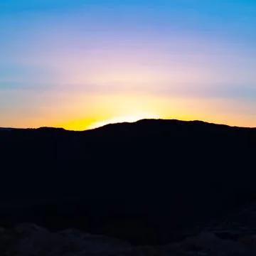 The exact moment when the sun sets behind the mountains Stock Photos