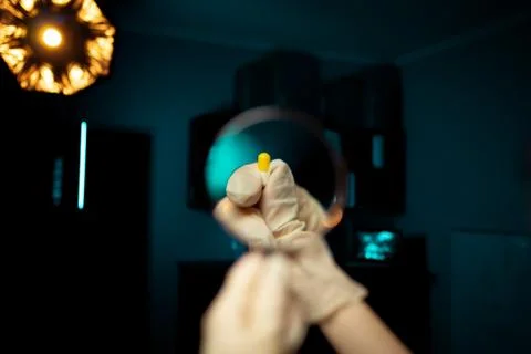 Examination of tablets for doping control under a magnifying glass Fotos Stock