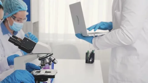 Examination under a microscope, african american laboratory assistant with a Stock Footage 230455894
