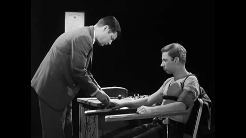 An Examiner explains features of a polygraph machine, including a pneumograph Stock Footage 79524355