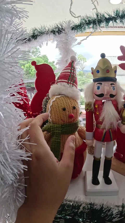 Examining the design of a nutcracker and gingerbread Christmas ornament display  Stock Footage 317492255