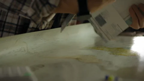 Examining a map for navigation in a warm indoor setting during evening hours Stock Footage 295896978