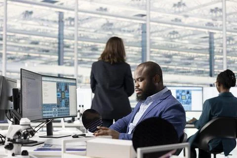 Examining microchip circuit design, specialized software and technician using PC Stock Photos
