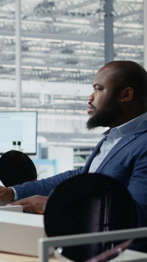 Examining microchip circuit layouts, computer monitor and man in factory office Stock Footage 335882844