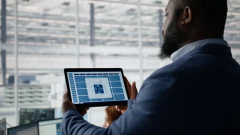Examining microchip circuit layouts, tablet close up and engineer in factory Stock Footage 335882381