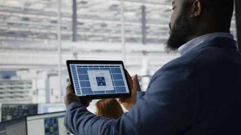 Examining microchip circuit layouts, tablet close up and engineer in factory Stock Photos