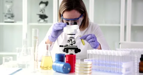 Examining oil sample under microscope Stock Footage 249877975