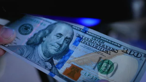Examining one hundred dollar banknote with a money detector. Detector banknotes. Stock Footage 166723351