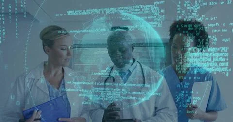 Examining tablets, white coat doctors and scrub nurse in ward corridor, with Foto stock