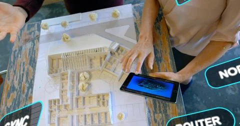 Examining white scale model, two designers touching 3D tablet in design studio, Stock Photos