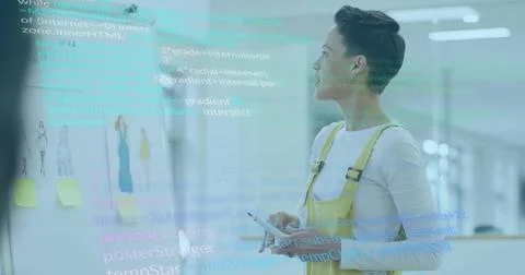Examining whiteboard sketches and code, woman in overalls holding stylus and  Photos