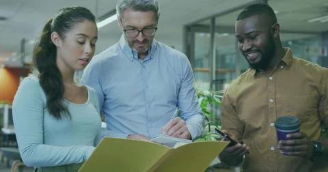 Examining yellow folder, professionals collaborating in open-plan office, with Stock Photos