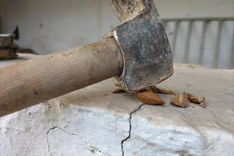 An example of a bad idea is to crack apricot nuts with a hammer on a ceramic  Foto stock