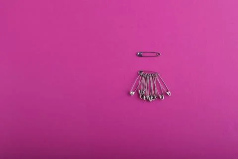 An example of a beautiful safety pin in silver, below is a large bunch of saf Stock Photos