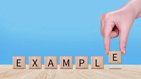 Example concept, Example word written on wooden block, example text on tabl.. Stock Photos
