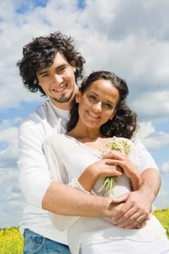 Example of harmony in love: young man hugging charming lady in white clothing wh Stock Photos