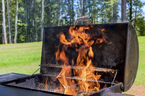 An example of how to prepare a BBQ for grilling meat using firewood and a Stock Photos