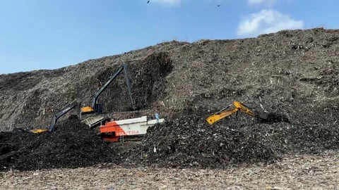 Excavating and moving waste at a massive garbage dump. Huge mountain of trash Stock-Footage 336067544