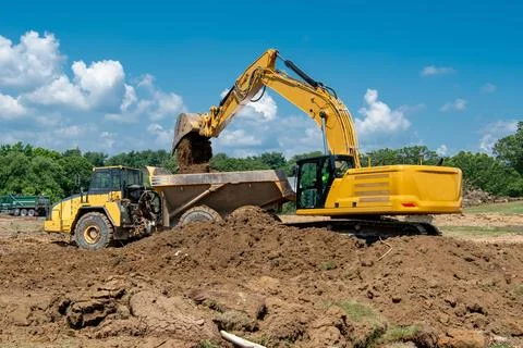 Excavation and loading into dump trucks with excavator Stock Photos