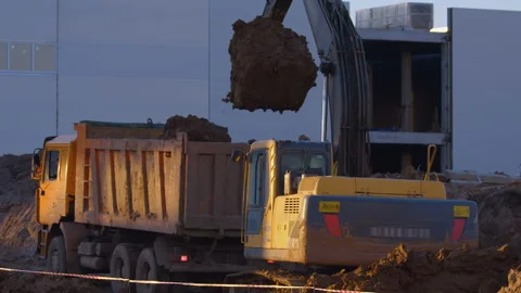 Excavation at a construction site, excavator loads the truck with earth  Stock Footage 147633485