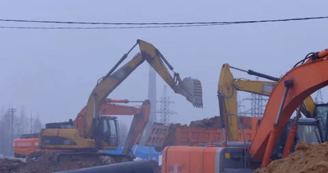 Excavation at a construction site, excavators loads the trucks with earth  Stock Footage 147603661