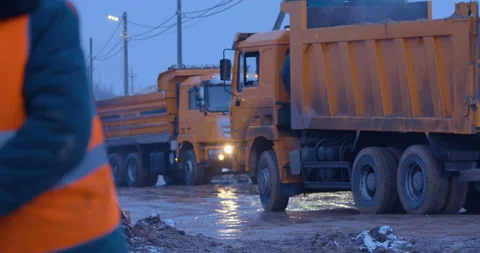 Excavation at a construction site, worker reel dirty electrical cable  Stock Footage 147621450