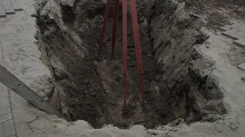 Excavation process: heavy machineries lifting soil from deep construction trench Stock Footage 318161040