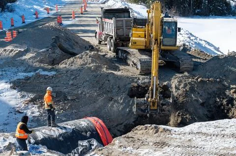 Excavation work on a road in winter 스톡 사진
