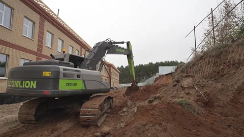 Excavator actively digs into large mound of dirt and debris Stock Footage 311108462