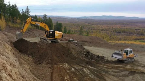 Excavator and bulldozer work in a sand pit in the forest Stock Footage 236401029