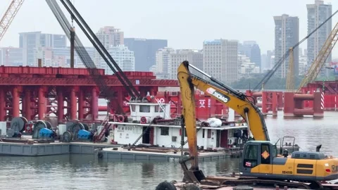 Excavator and construction vessels operate on Qiantang River bridge project in Stock Footage 335355174