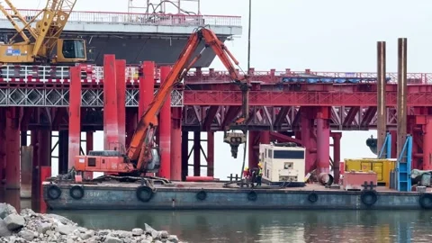 An excavator and construction vessels operate on the Qiantang River bridge Stock Footage 335995835