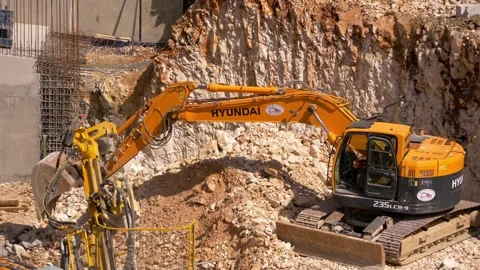Excavator and Drill on Rock Construction Site – Heavy Machinery in 4K Stock Footage 313655421